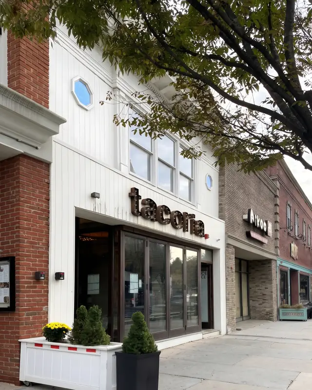 The Tacoria storefront at 52 South Street with planters of yellow mums out front.